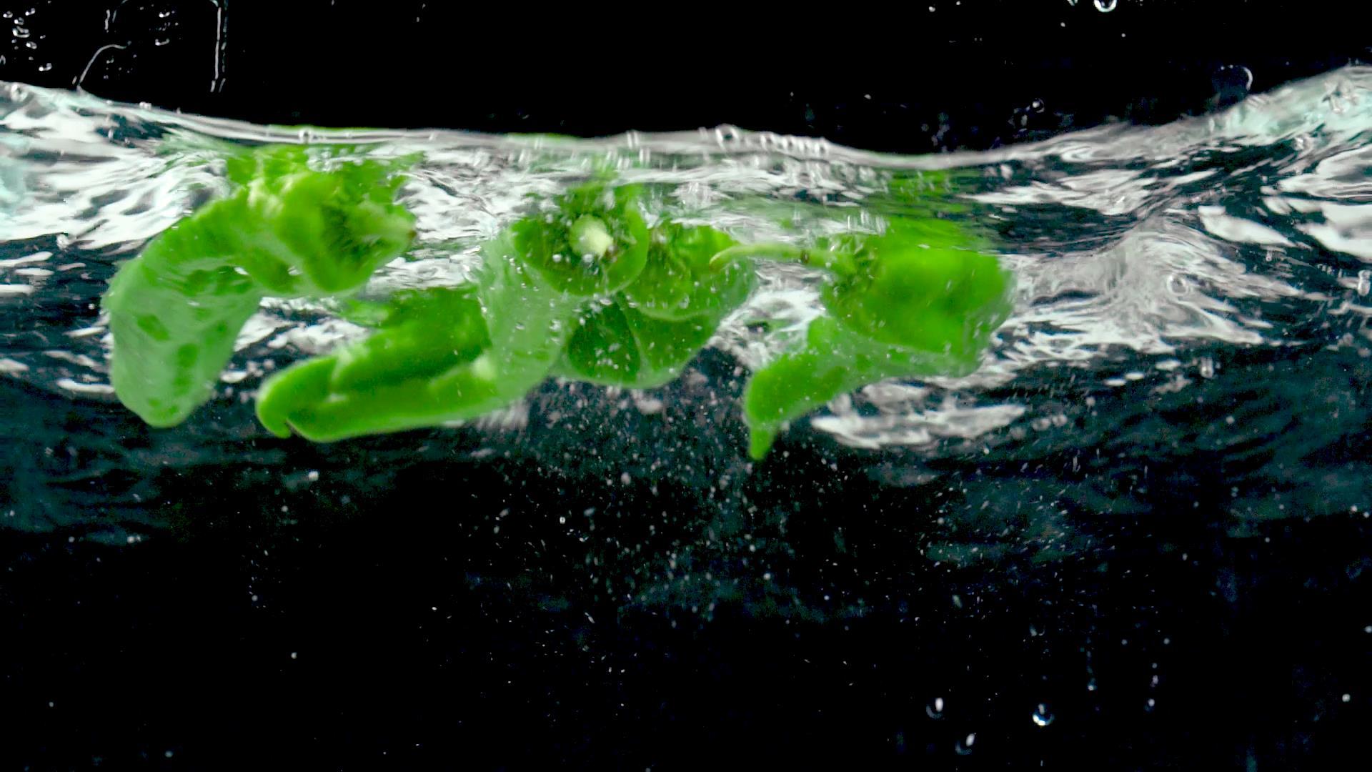 新鲜青椒落入水中高速视频视频的预览图