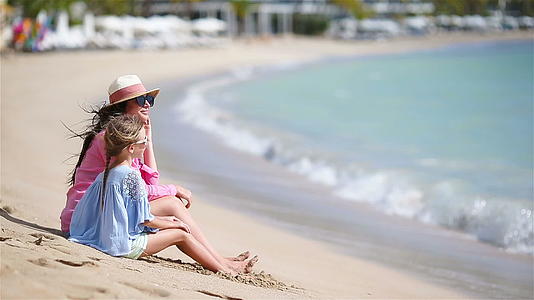 卡西比海滩上美丽的母亲和女儿视频的预览图