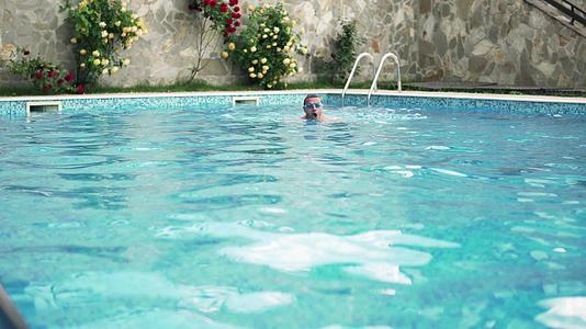男人在豪华游泳池电影Dof在相机前面使用相机视频的预览图