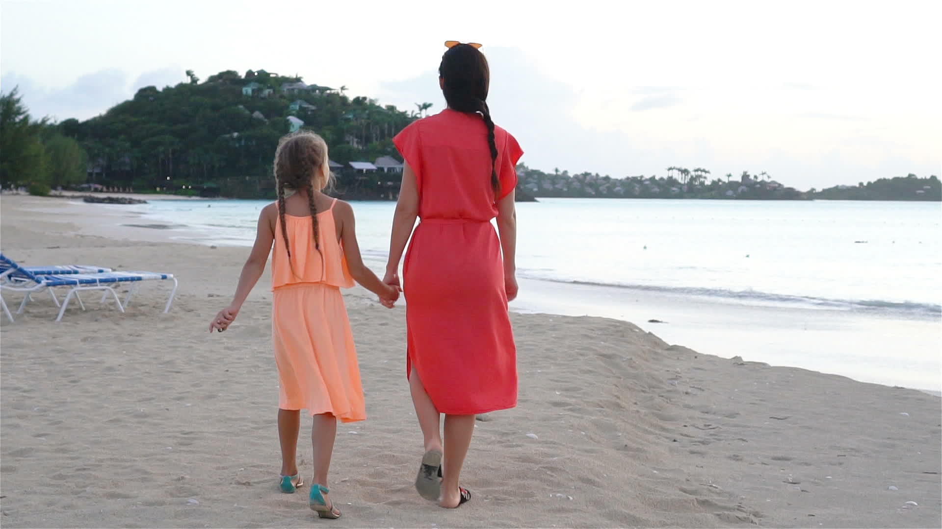 美丽的年轻母亲和可爱的小女儿在热带海滩上玩得很开心视频的预览图
