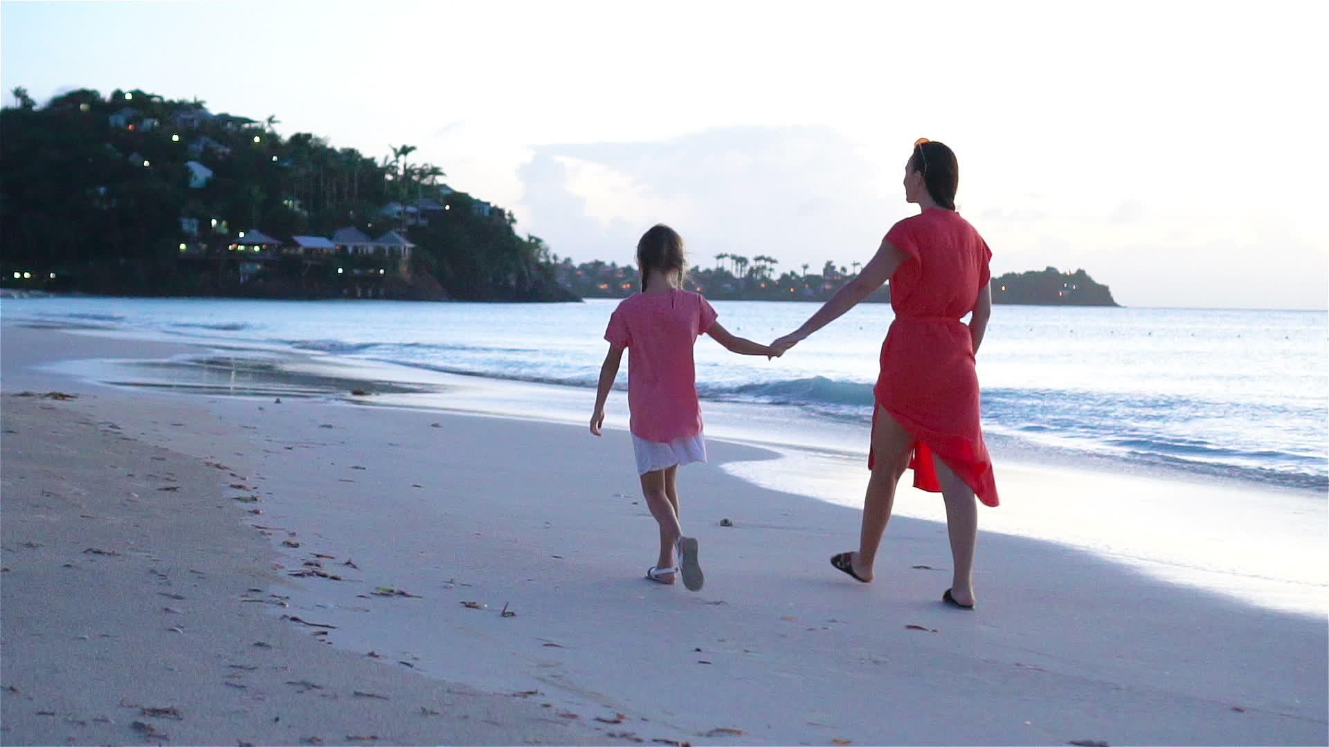 年轻美丽的母亲和可爱的小女儿在热带海滩玩得很开心视频的预览图