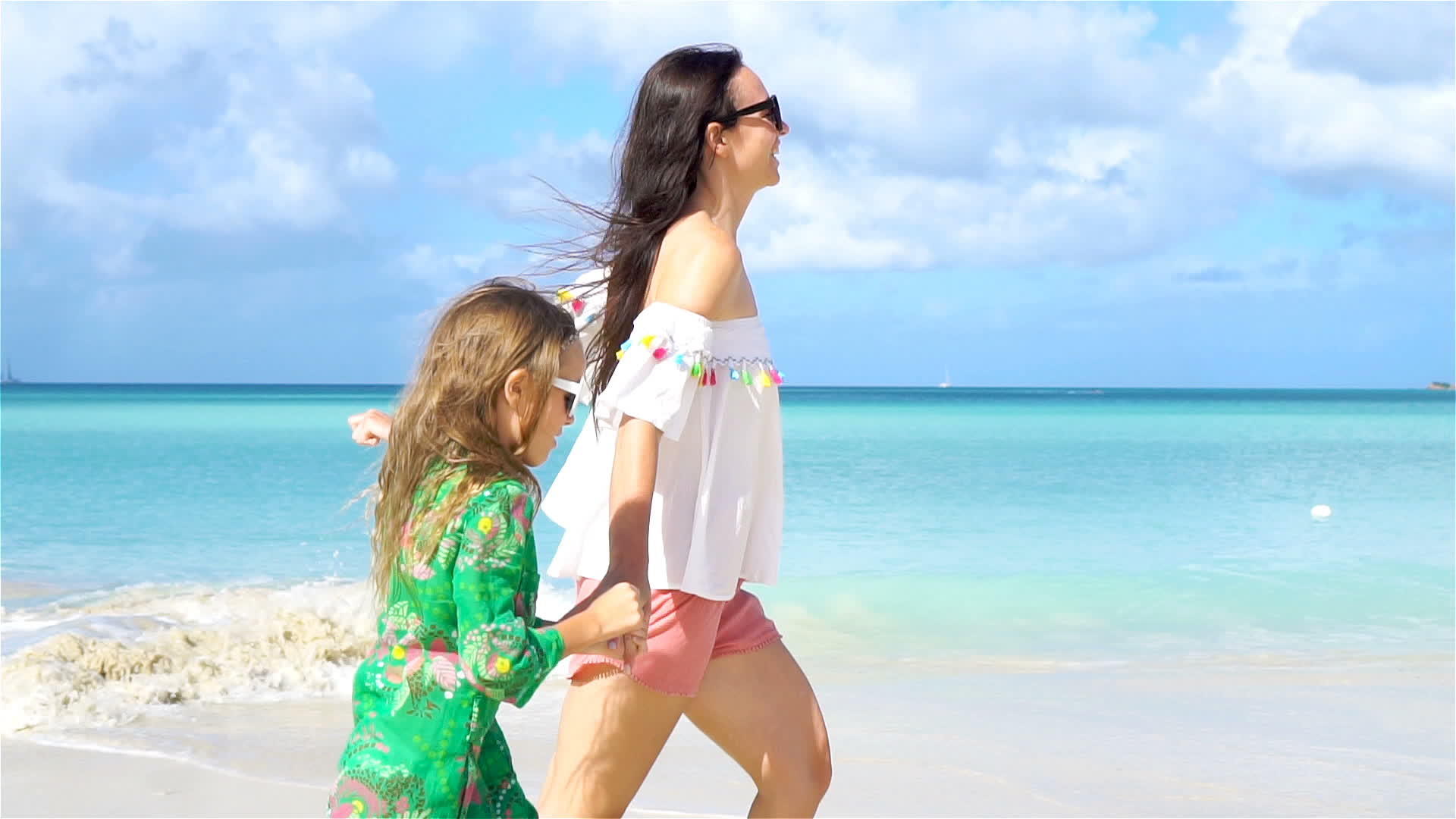 母亲和女儿在热带海滩上散步视频的预览图