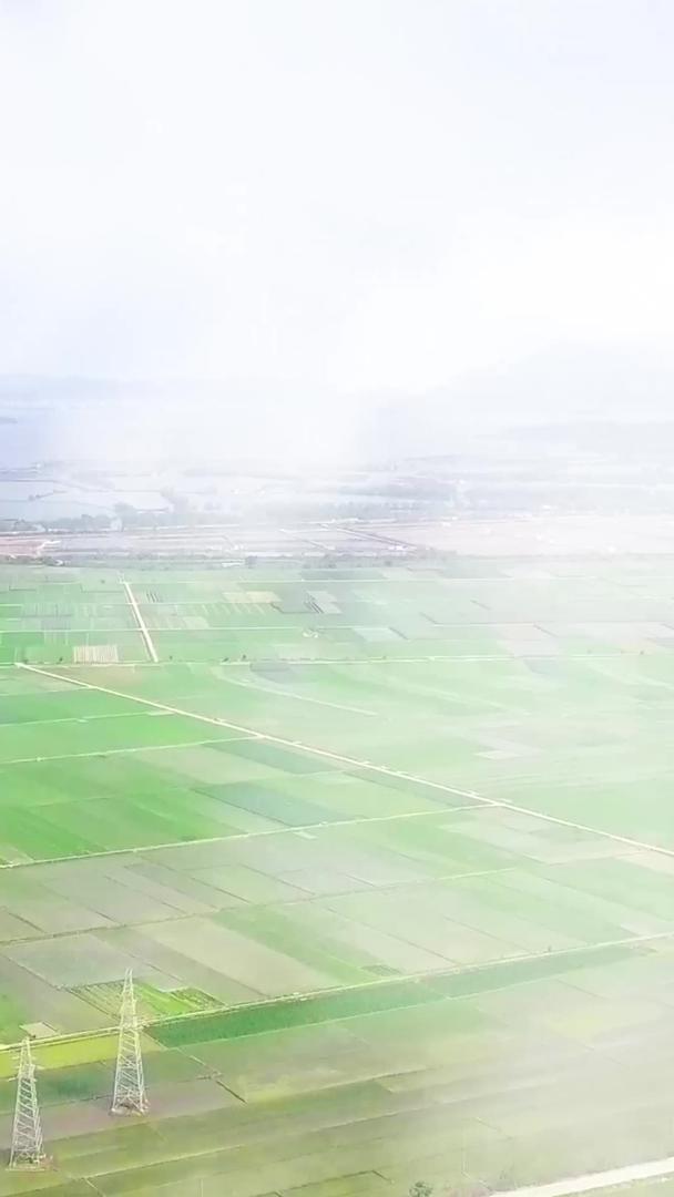 通过云层航拍可以看到邻海农村的开阔田野视频的预览图