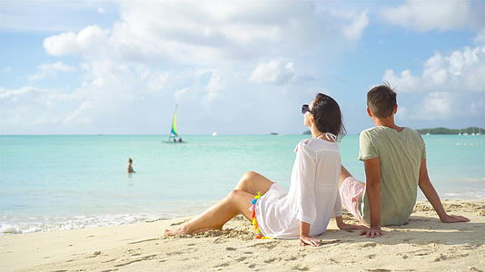 暑假期间白沙滩上的年轻夫妇视频的预览图