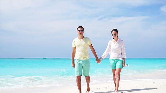 在夏天的假期里年轻夫妇在白色海滩上享受他们的蜜月和慢动作视频的预览图