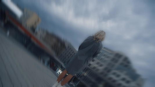 孤单的女人在傍晚的路灯下看着城市景观中的云彩视频的预览图