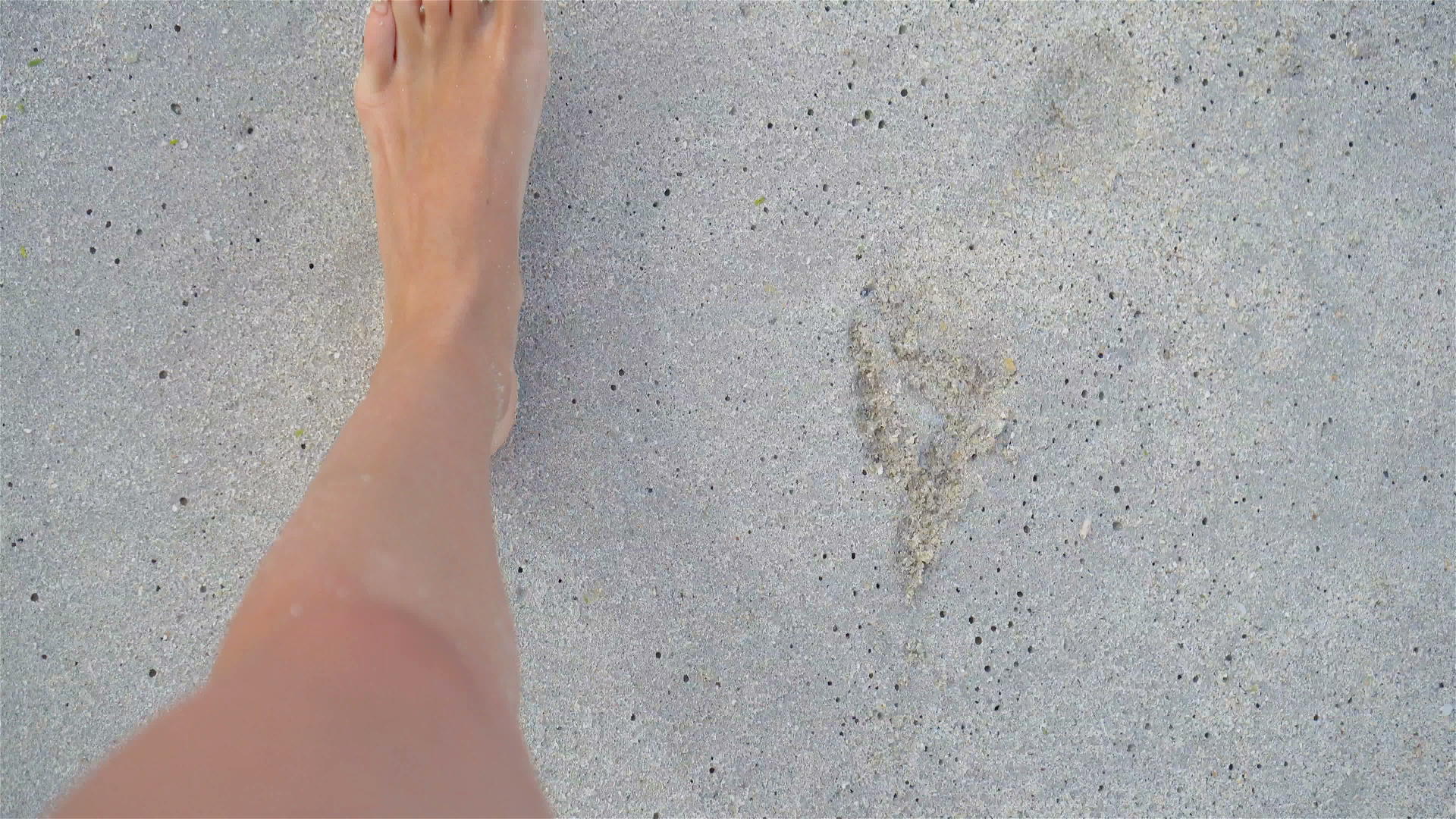 赤脚走在白色海滩上的女人的脚视频的预览图