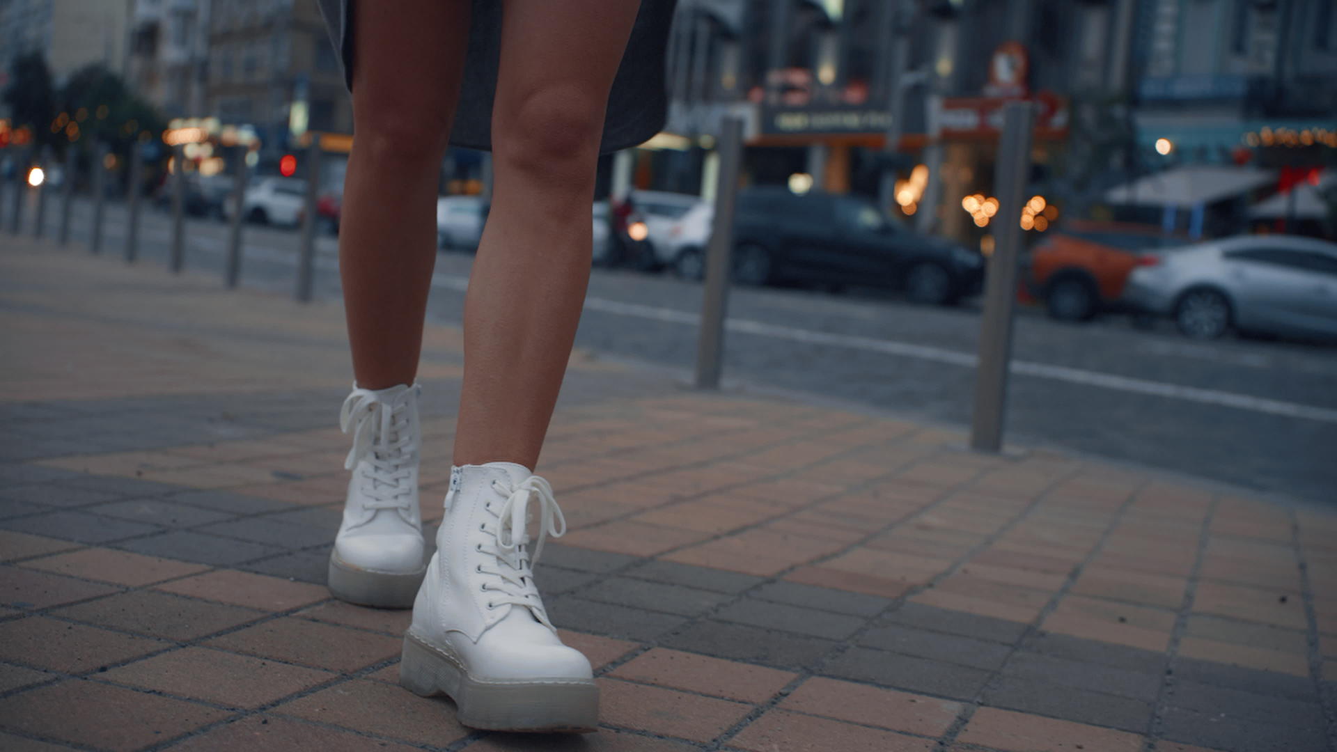 晚上女人的腿在城市附近的公路交通灯附近行走视频的预览图
