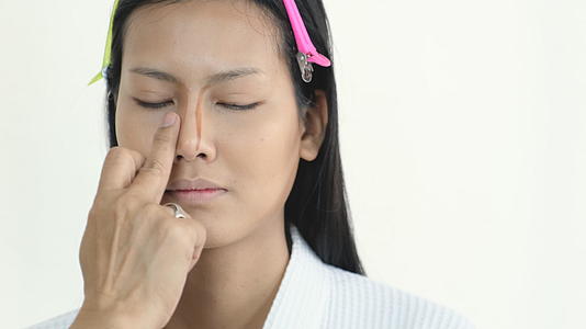 化妆师把化妆品应用到亚洲美女的鼻子上视频的预览图