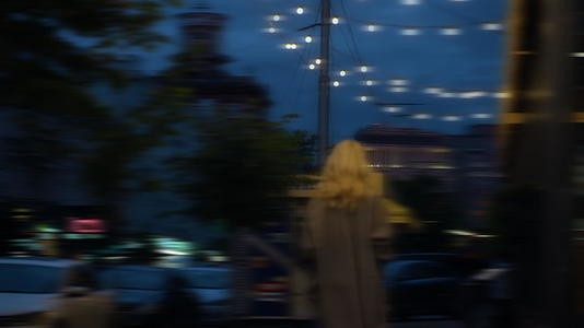 女士在城市背景建筑中行走夜晚城市照明视频的预览图