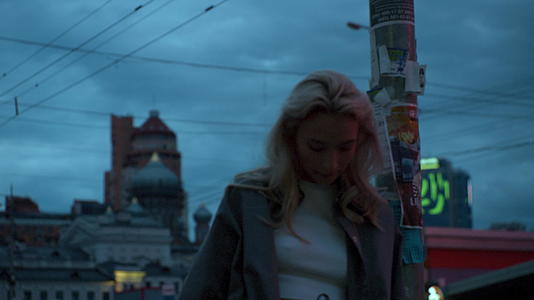 晚上城市里的女孩站在城市景观路灯附近视频的预览图