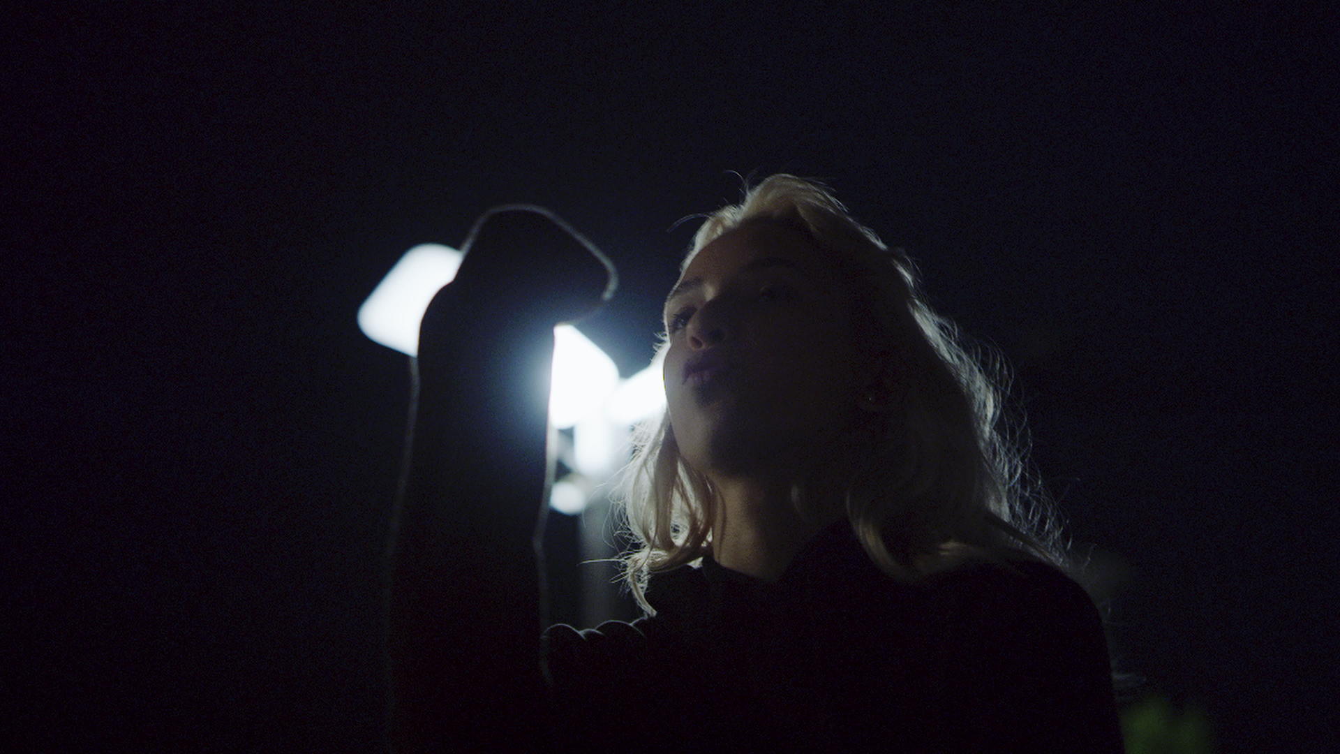 晚上在城市的灯光下做动作的金发女人视频的预览图