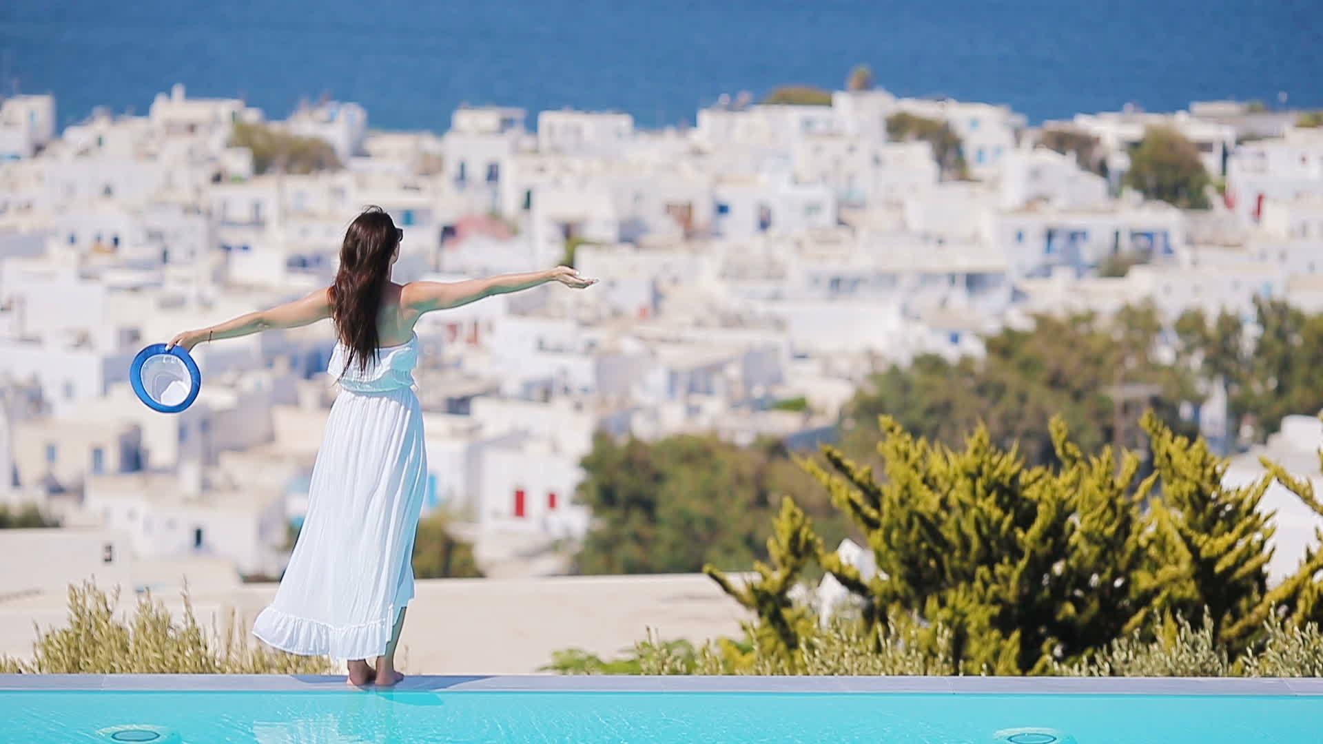 漂亮的年轻美女在游泳池附近放松看着美丽的风景Mykonos视频的预览图