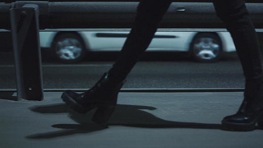 在深夜的黑暗中女人的腿和过去的汽车一起走在高速公路上视频的预览图