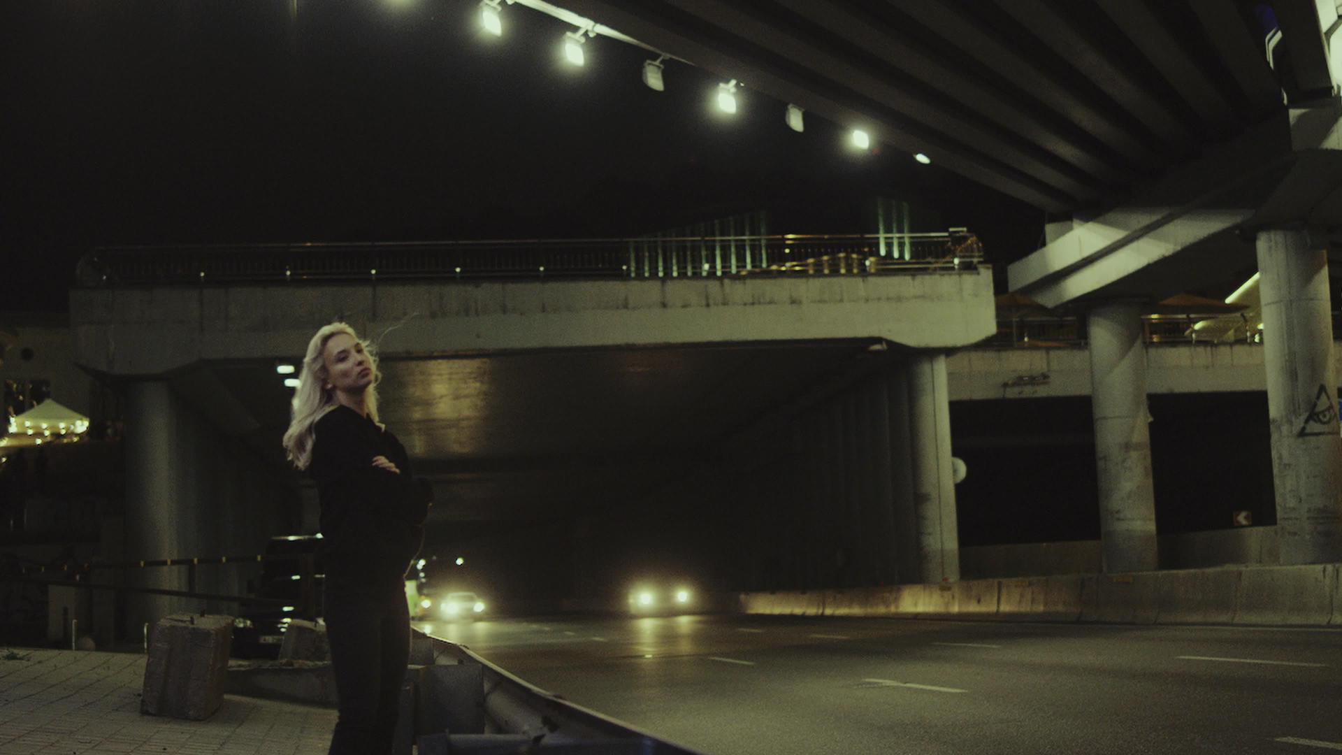 孤独的女孩站在高速公路上看着汽车通过隧道行驶视频的预览图