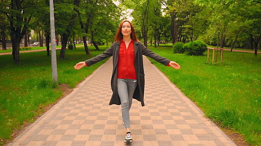 快乐的红发女人在公园里散步视频的预览图