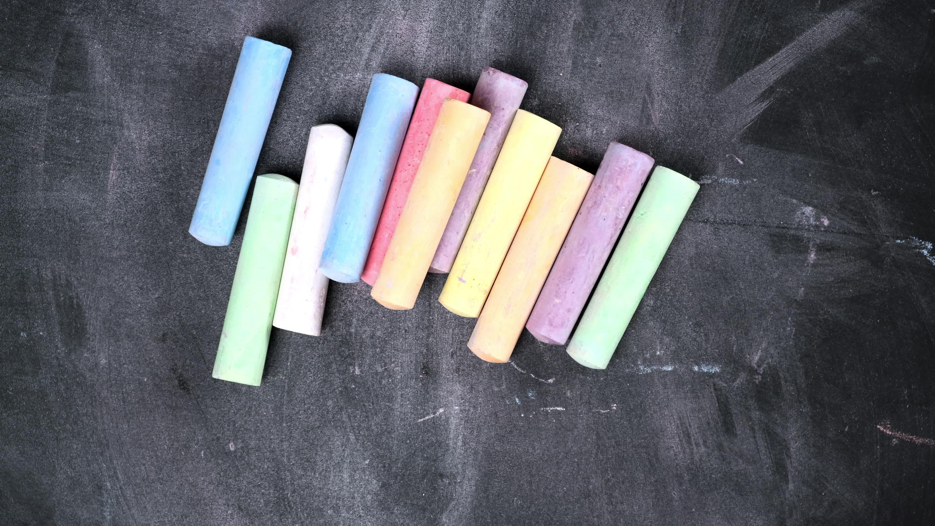 一堆彩色蜡笔被放置在黑色的表面上视频的预览图