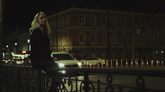 女孩们晚上坐在长椅上在城市的灯光下享受城市生活的中心视频的预览图