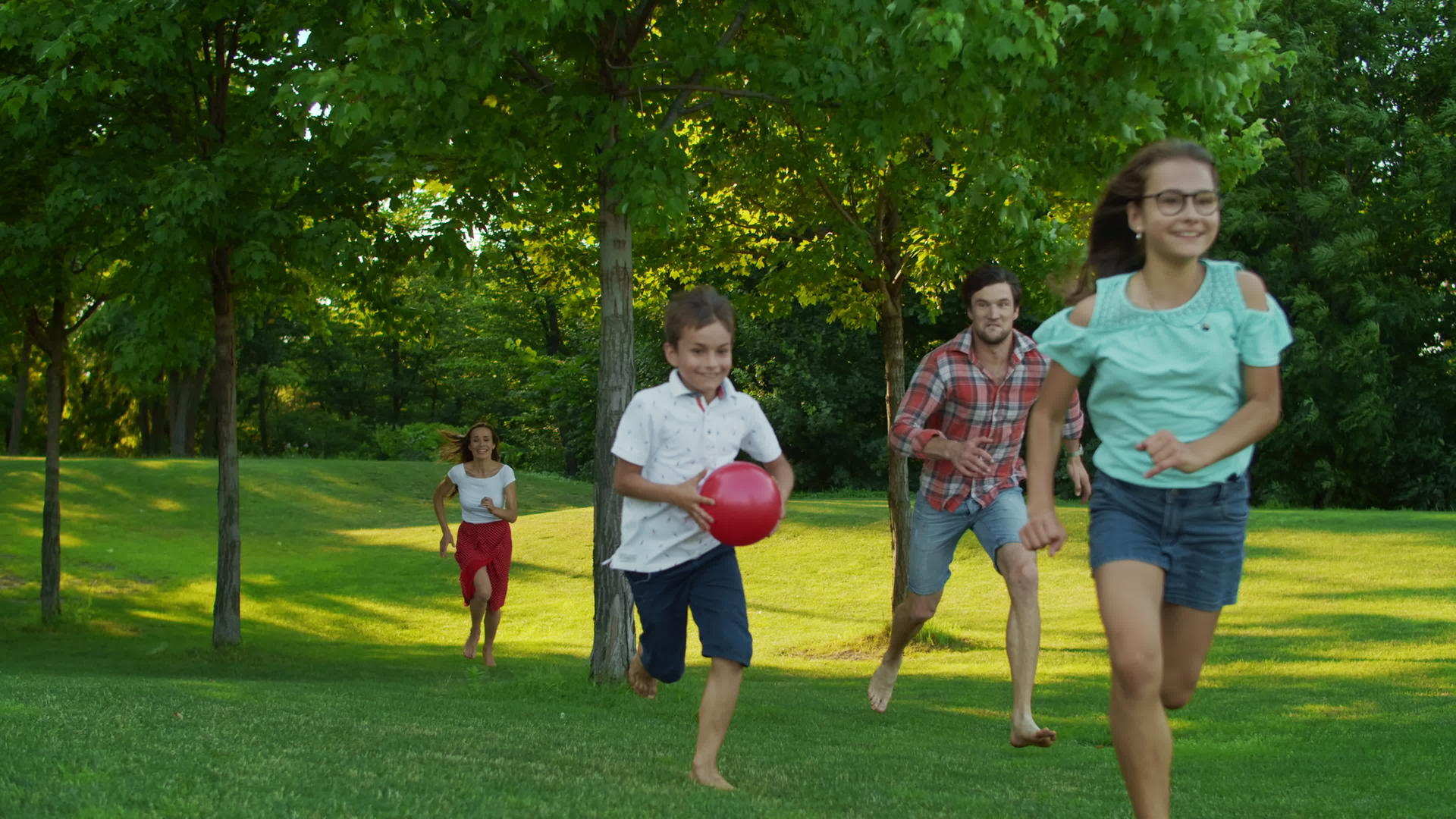 孩子们的父母在夏天的公园里跑步视频的预览图