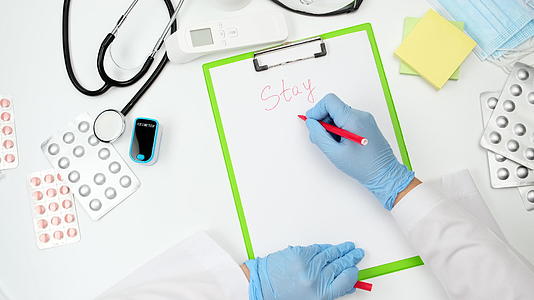 医生穿着蓝色乳胶手套和白色外套在一张纸上用红笔写字视频的预览图