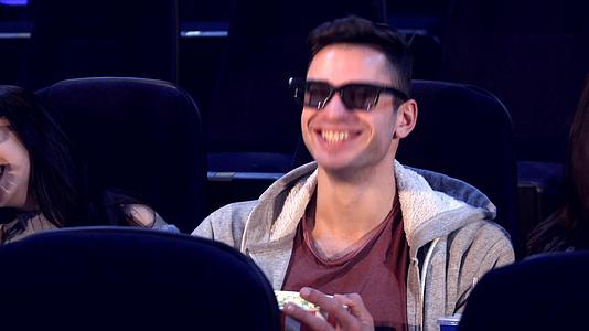 男人坐在两个女孩中间在电影院里视频的预览图