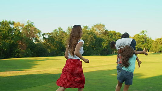 快乐的孩子和父母在草地上打球视频的预览图