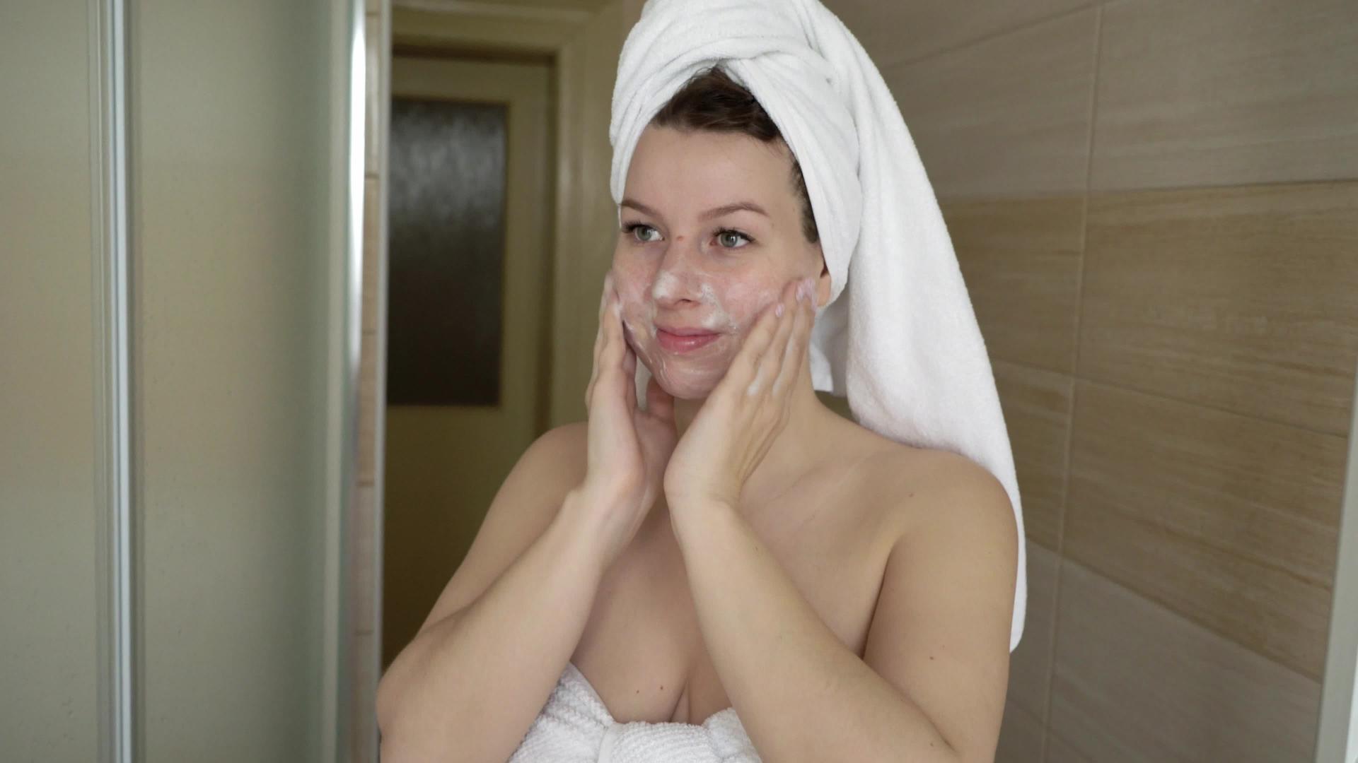 洗脸的女人在浴室用泡沫洗脸视频的预览图