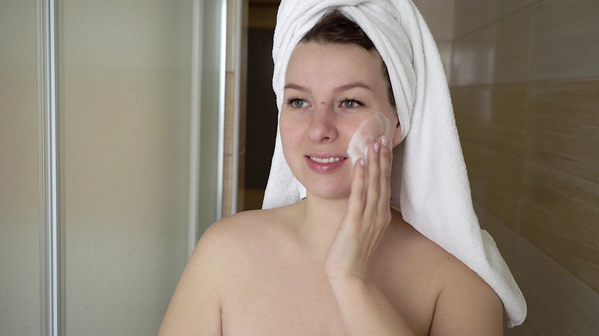 洗脸的女人在浴室用泡沫洗脸视频的预览图