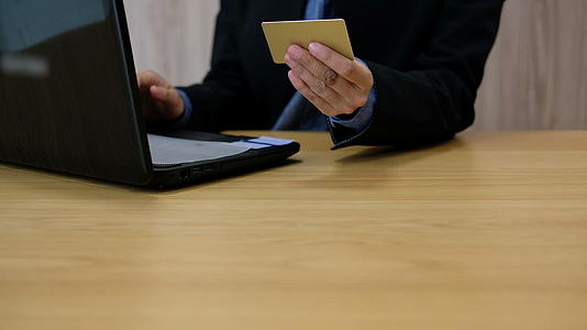男子使用信用卡和电脑进行网上购物商人从互联网上购买视频的预览图