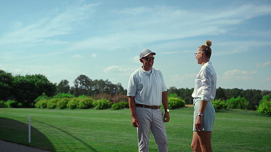 两名高尔夫球手在球场上谈论运动视频的预览图