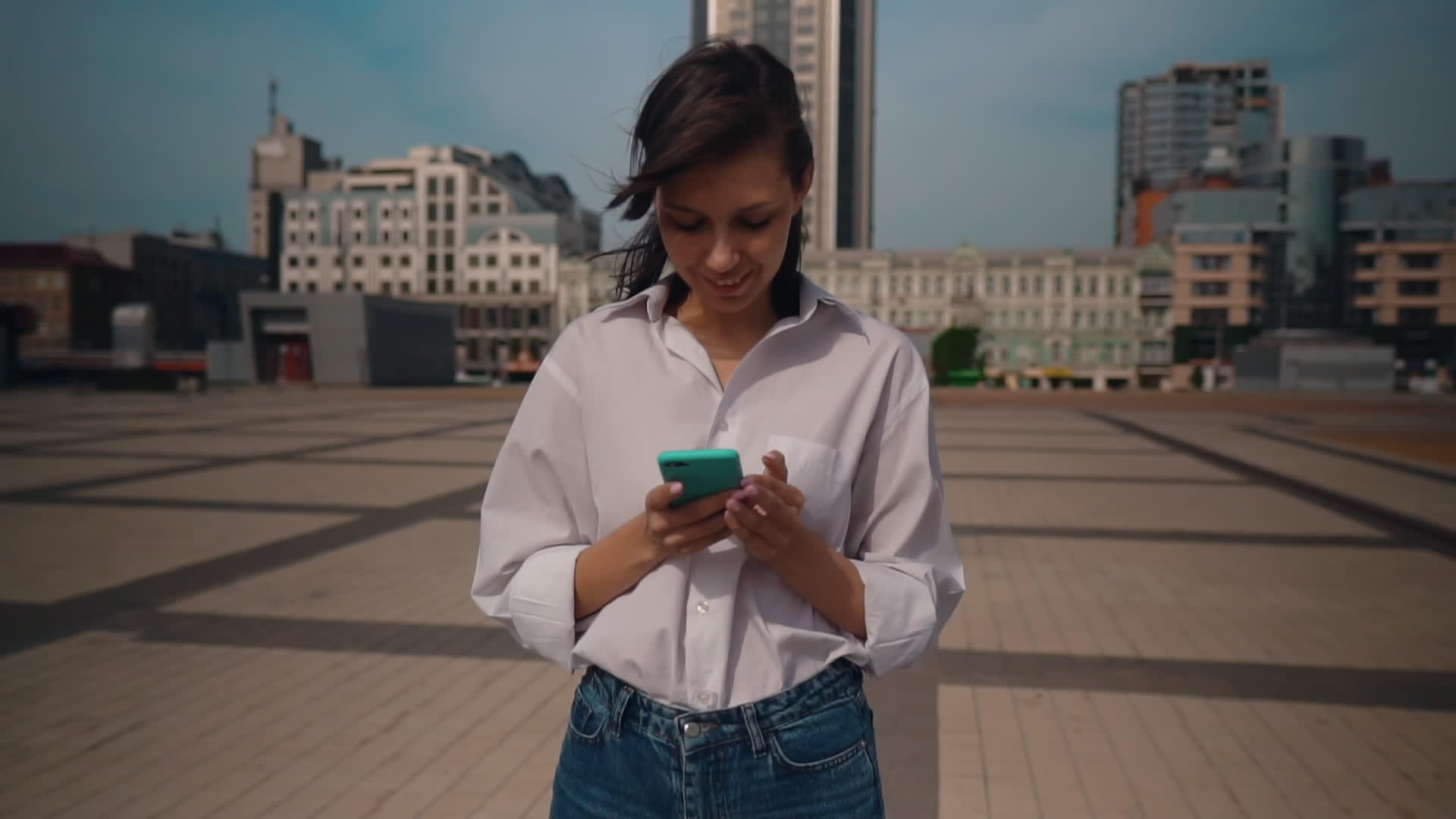 穿着白衬衫的女性在智能手机上滚动触摸屏幕视频的预览图