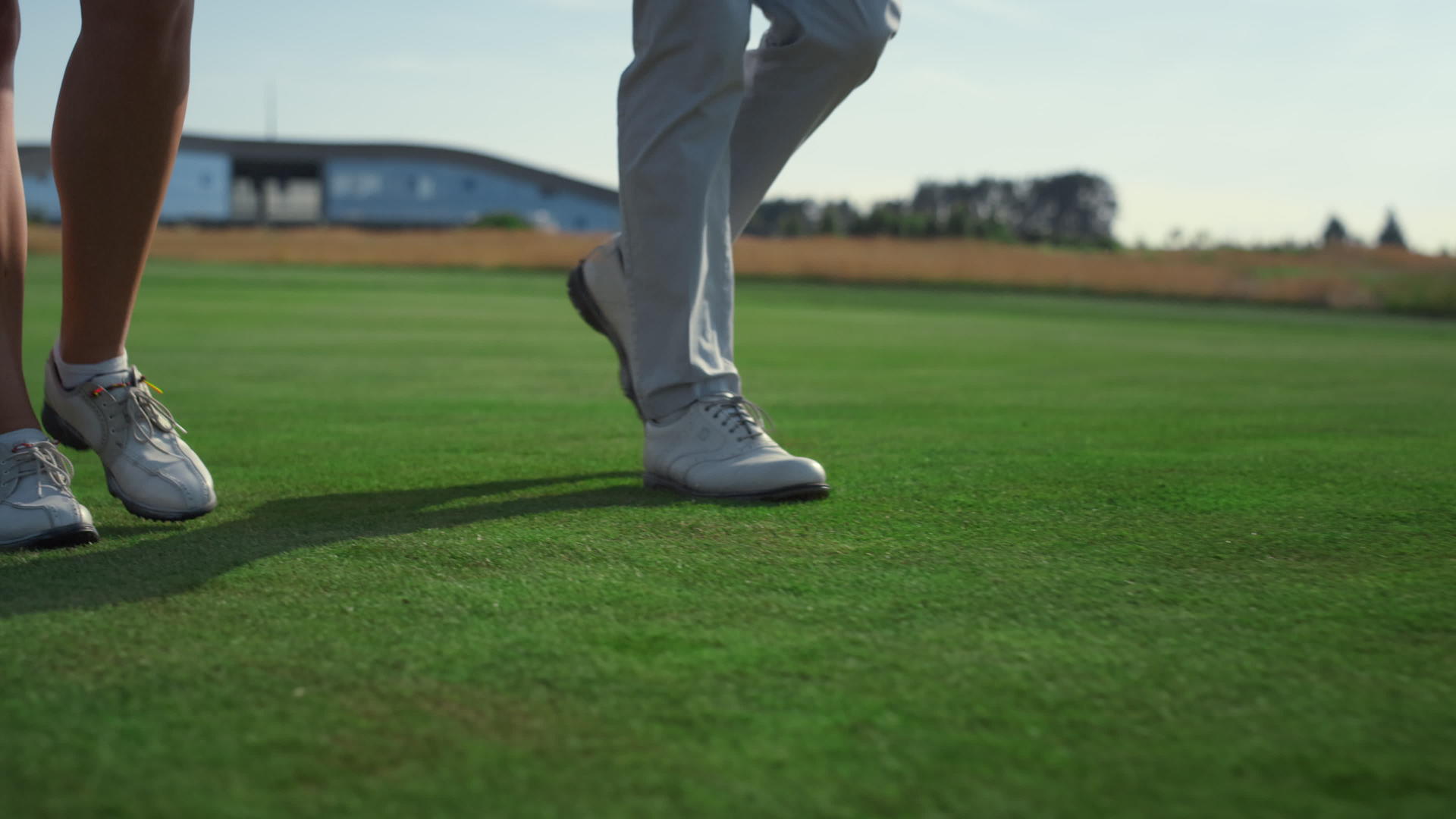 高尔夫夫妇的腿在球场草地上行走视频的预览图