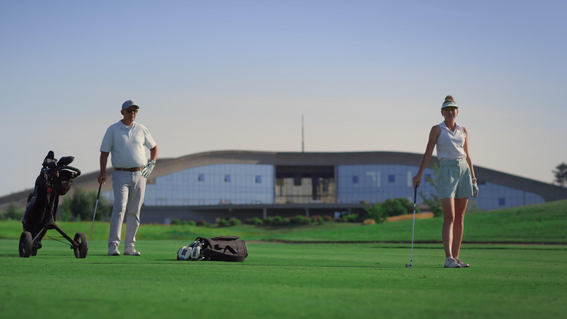 商务夫妇在球场上打高尔夫球视频的预览图