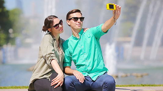 来欧洲度假的年轻旅游夫妇在公园的背景下在大喷泉里开怀大笑视频的预览图