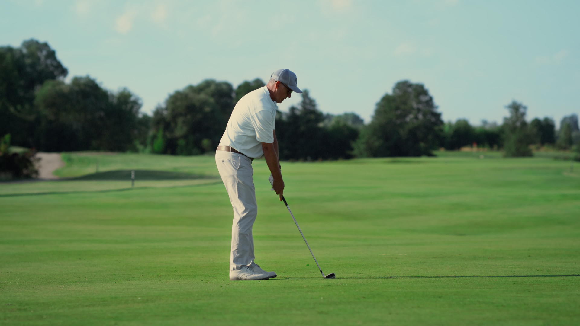 老人在草地球道上打高尔夫球视频的预览图
