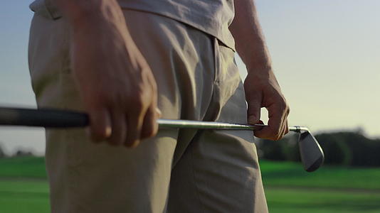 在日落球场上高尔夫球手手持推杆视频的预览图