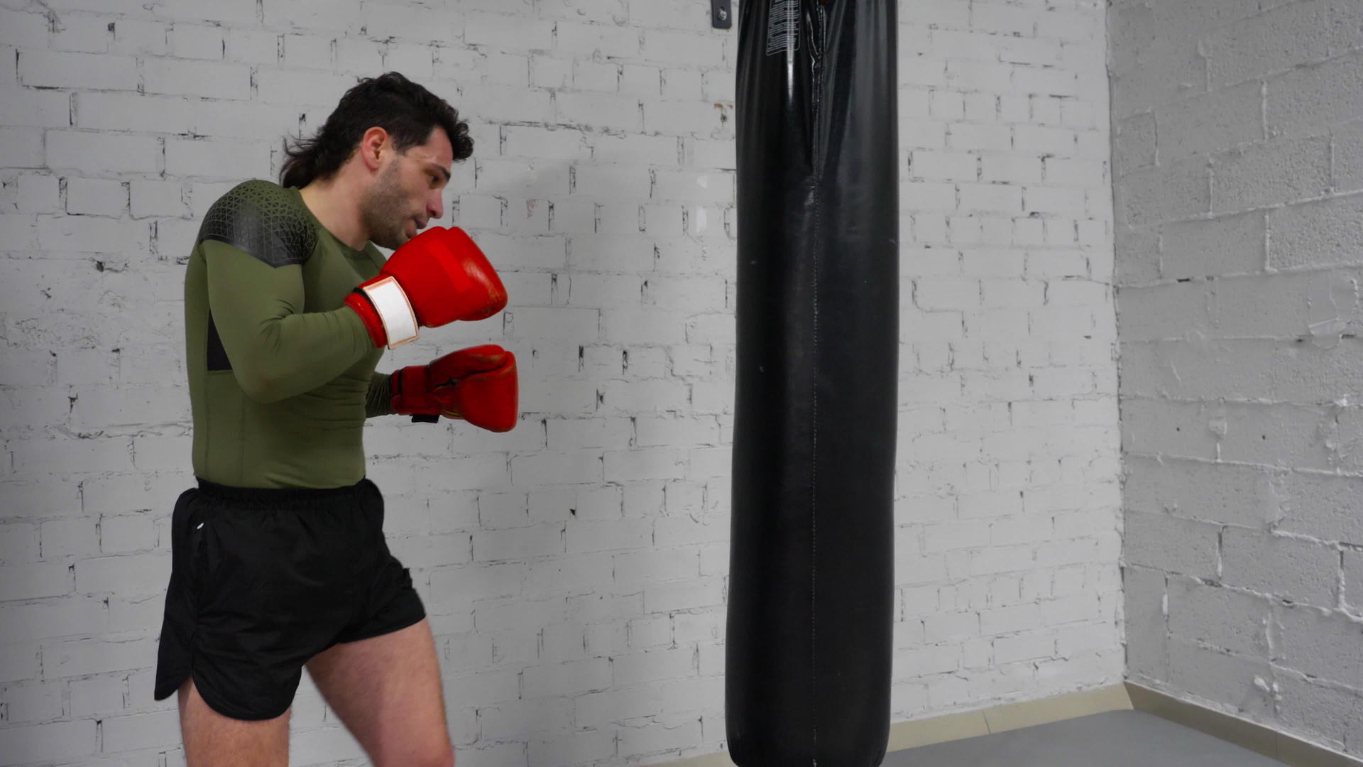 职业拳击手正在体育场训练用拳击袋踢和用拳头练习笑声视频的预览图