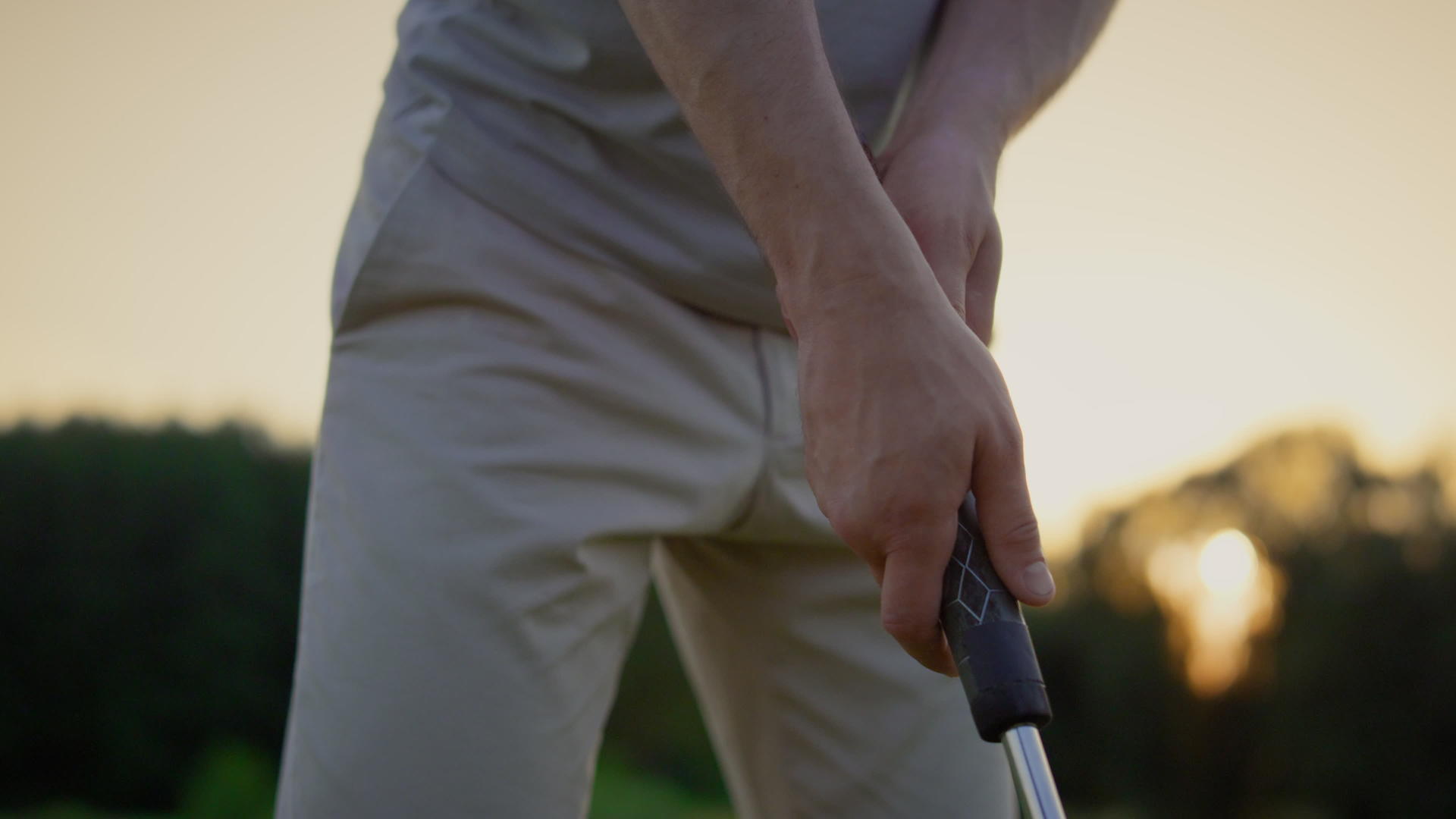 职业高尔夫球手手持俱乐部推杆在日落球道上举行视频的预览图