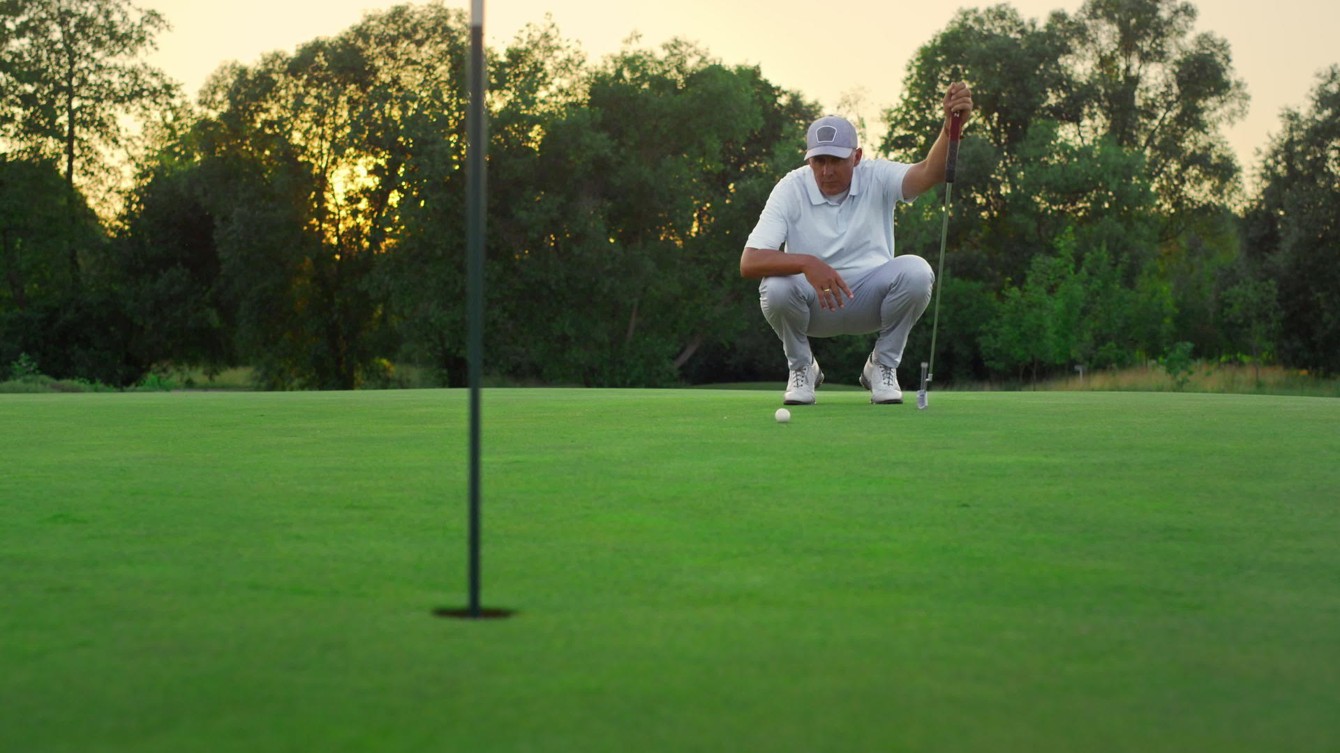 高尔夫球手在郁郁葱葱的草地上观看球场视频的预览图
