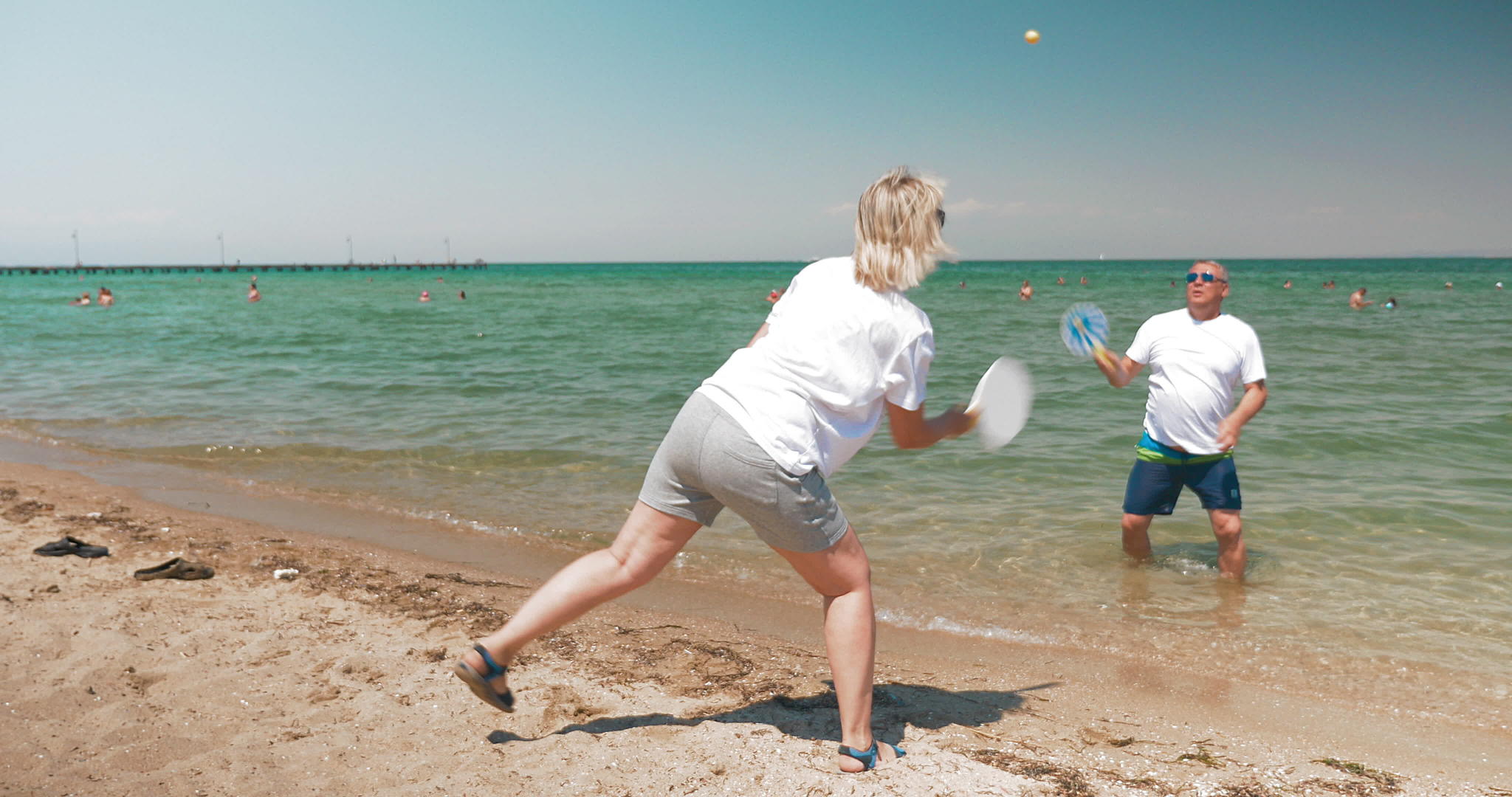 男人和女人在海滩上打羽毛球视频的预览图