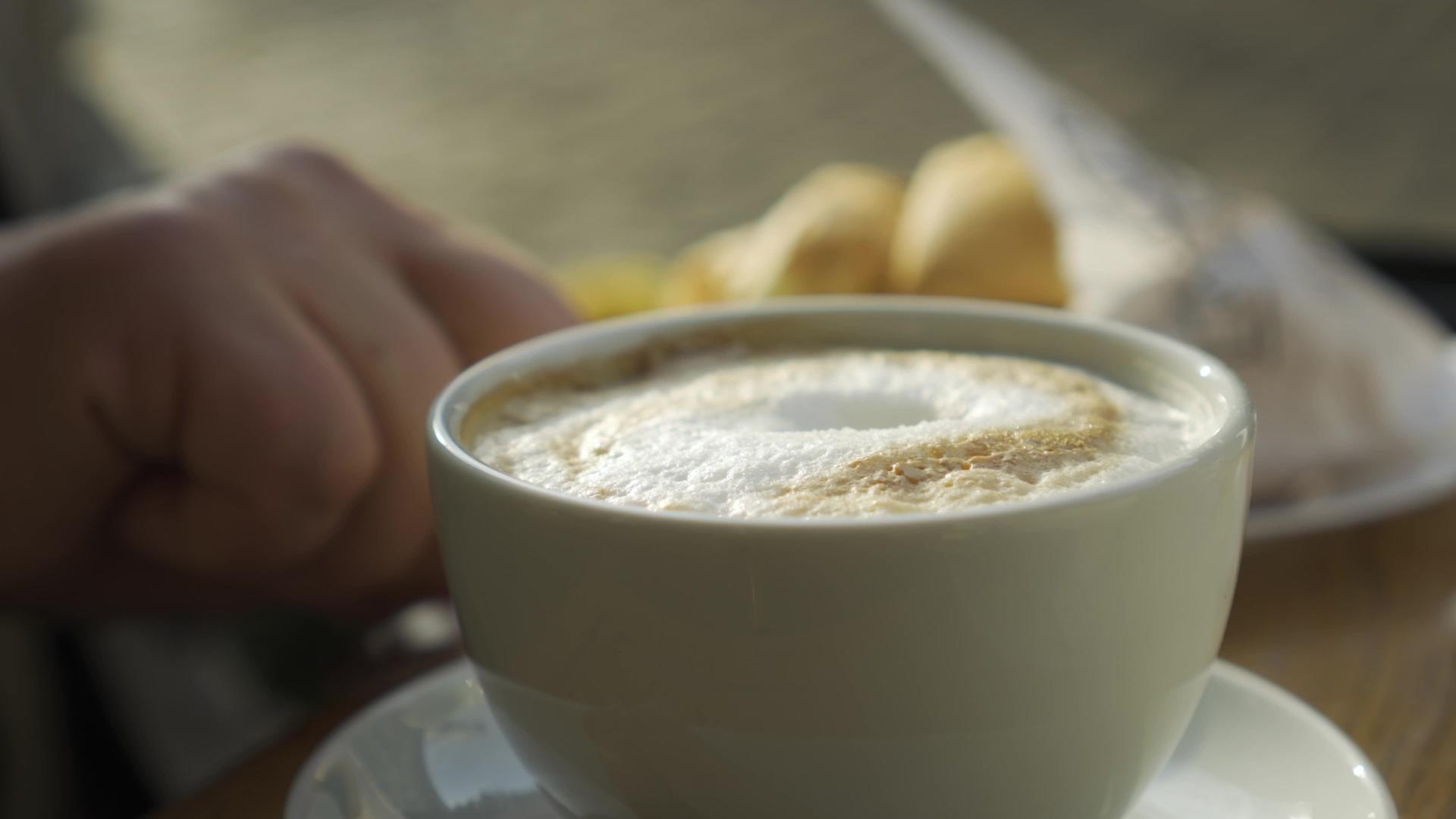 卡布奇诺咖啡杯坐在旧城咖啡馆的室外座位上视频的预览图