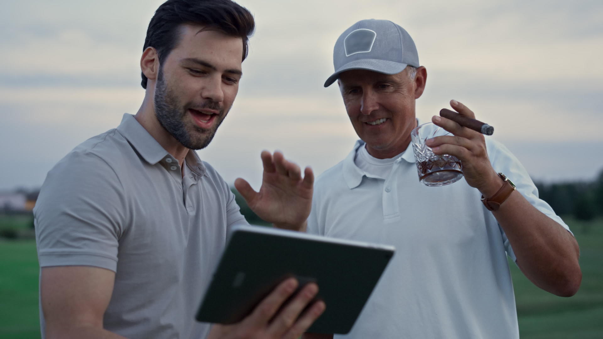 两名高尔夫球手在田野上搜索平板电脑视频的预览图