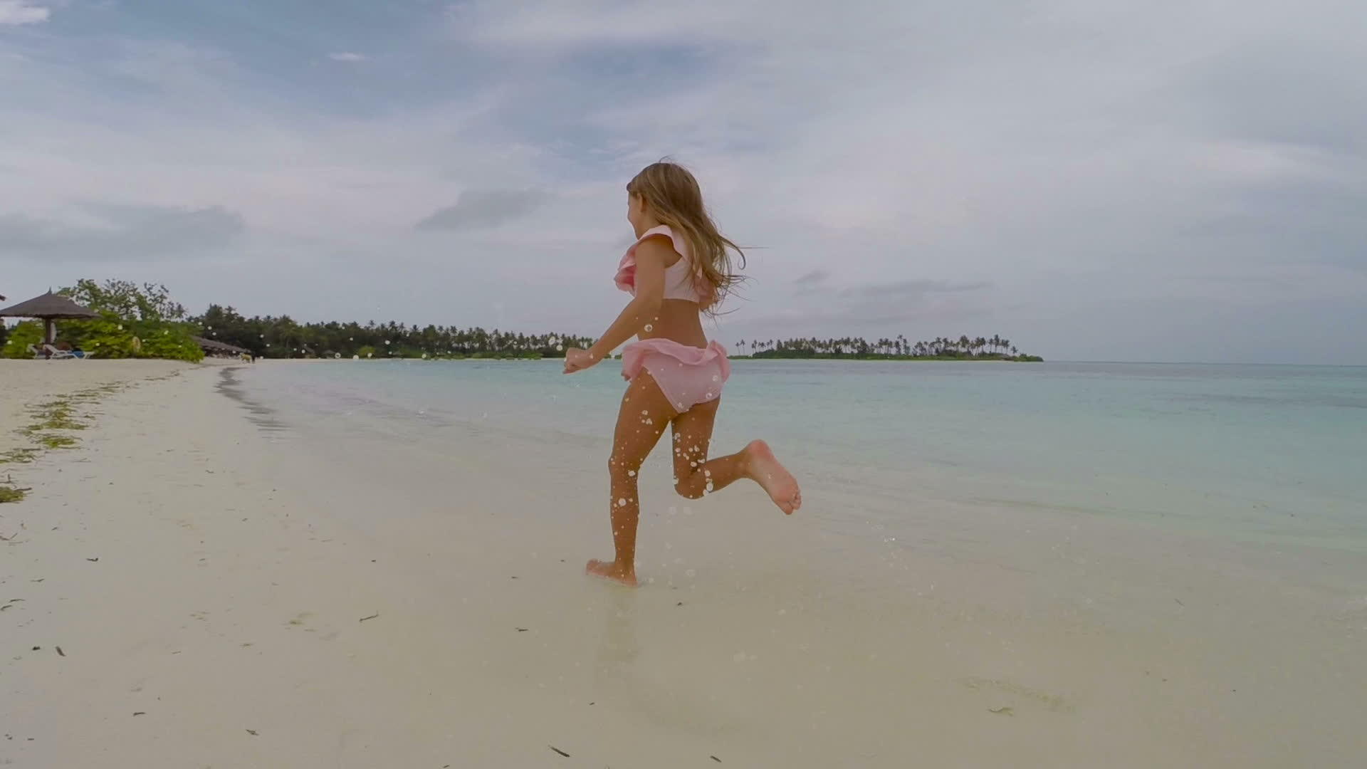 暑假期间快乐的小女孩在海滩上玩得很开心视频的预览图