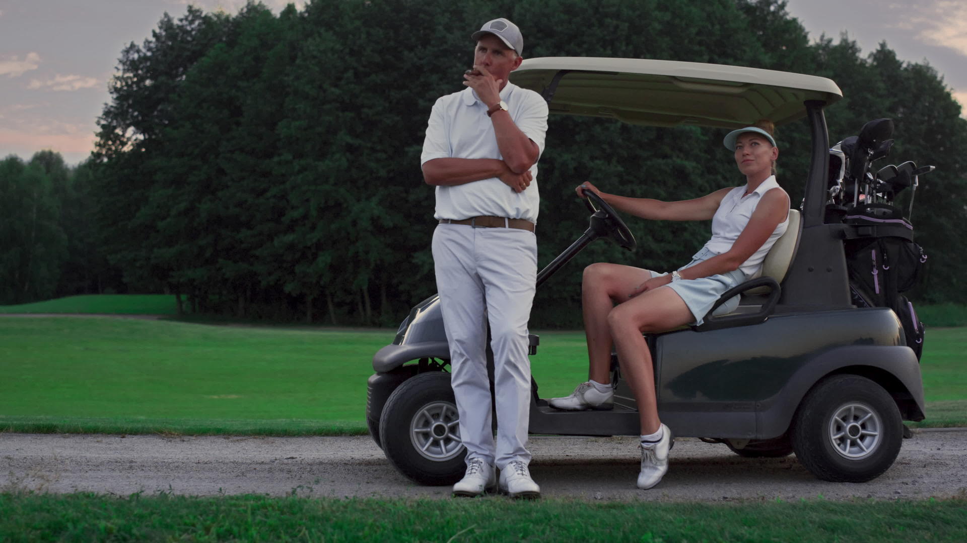 沉思资深高尔夫球手站在高尔夫球车上视频的预览图