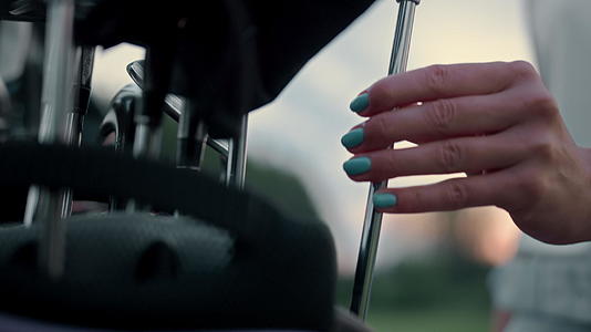 女性手持高尔夫球杆在运动器材包中视频的预览图