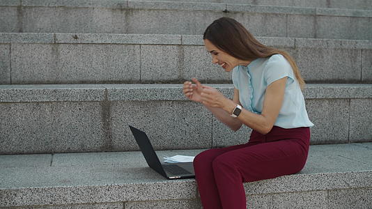 商业女性在笔记本电脑上读到好消息视频的预览图