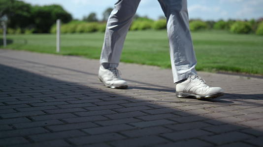 高尔夫球手的腿在球场上行走视频的预览图
