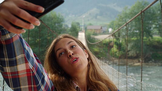 在山区自然背景下女游客使用手机自拍视频的预览图