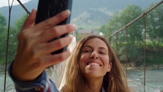 在山区自然景观中美丽的女性用手机拍照自拍视频的预览图