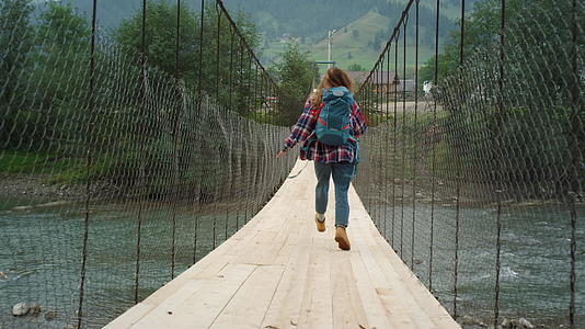 兴奋的旅游徒步旅行者在河桥上奔跑视频的预览图